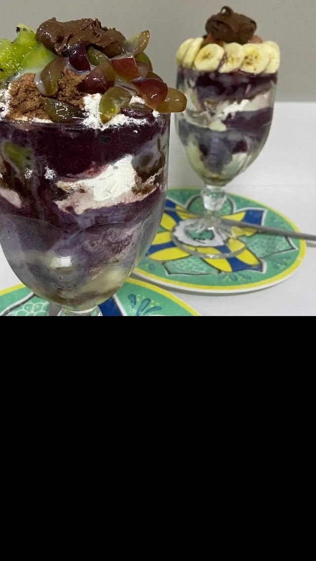 Duas taças de açaí com frutas servidas no balcão